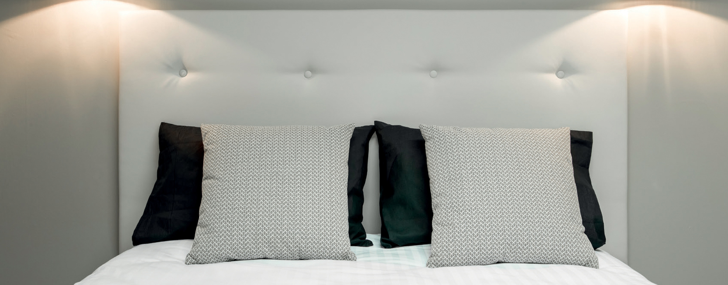 Tête de lit hôtel capitonnée avec coussins assortis