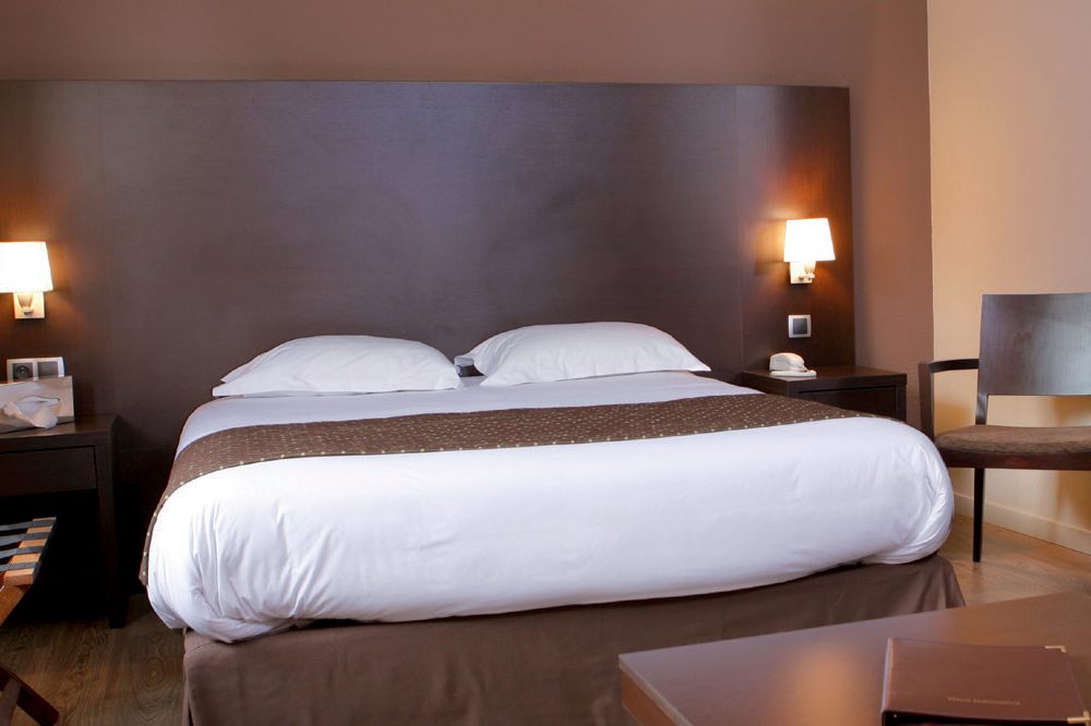 Décoration chambre hôtel chaleureuse et contemporaine avec  liseuses tête de lit