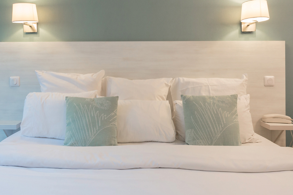 Décoration chambre d’hôtel moderne : Tête de lit panneau, coussins design